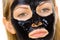 Woman with black peel off mask on face