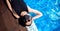 Woman in black protective mask from coronavirus bathes in hotel pool, summer epidemic vacation. Social distance concept