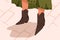 Woman in black trendy cowboy or cossack boots. Female legs in stylish comfortable elegant leather acute toe footwear