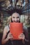 Woman in black witch costume with crown on head grimacing, holding red book