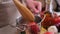 woman blanching tomato in pot with hot boiling water