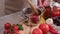 woman blanching tomato in pot with hot boiling water