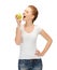 Woman in blank t-shirt eating green apple