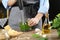 Woman blending pesto sauce in bowl at table