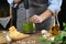 Woman blending pesto sauce in bowl at table