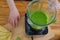 Woman blending spinach, bananas and almond milk to make a healthy green smoothie