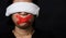 Woman blindfold wrapping mouth with red adhesive tape, tied with chains and closed her eyes