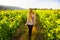 Woman with blond dreadlocks in the vineyards. Walking.