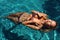 woman with blond hair in bikini relaxing in swimming pool