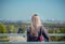 Woman with blond long hair observing cityscape