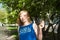 Woman blonde in blue dress walking along a city street against a background of urban architecture and summer Siberian beauties