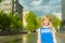 Woman blonde in blue dress walking along a city street against a background of urban architecture and summer Siberian beauties