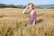 Woman blonde farmer on field of ripe wheat