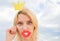 Woman blonde hair hold cardboard tiara or crown and red lips symbol of love sky background. So good to be queen. Lady