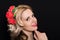 Woman with blonde laying and rimmed with red flowers on a dark background