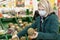 Woman blonde in a medical mask chooses fruit in a supermarket. Self-isolation in a pandemic