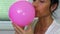 Woman blows the balloon close up