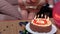 Woman blows candles on birthday party cake