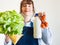 Woman in blue apron with food staples in hand