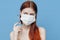 woman on a blue background in a medical mask and syringes in hand botox injection beauty care