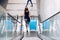 Woman with blue baggage suitcase on escalator