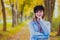 Woman in blue coat have a rest in autum park