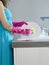 Woman In Blue Dress And Gloves Washing Dishes