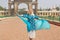 Woman in blue dress having fun near the Historical gates of the royal Palace of Mysore in Karnataka, India.