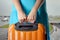 Woman in blue dress holds orange suitcase in hands