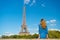 Woman in blue dress look at eiffel tower in paris, france, fashion. Woman with long hair, hairstyle, rear view, beauty. Fashion, s