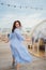 woman in a blue dress walks in a cafe in the shape of a igloo on roof.