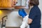 Woman with blue gloves cleans dishes in closet