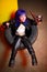 Woman with blue haircut in leather wear holding two guns sirs in the tire