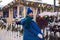 woman in a blue jacket and a green scarf and white gloves stands in winter on square in Moscow on Christmas Day