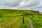 Woman with blue jacket hiking from Doolin to the Cliffs of Moher along the coastal walk route