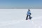 Woman in a blue jacket hiking on snow