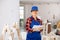 Woman in blue overalls checking completed construction work on drawing