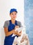 Woman in blue overalls checking completed construction work on drawing