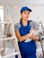 Woman in blue overalls checking completed construction work on drawing