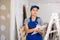 Woman in blue overalls checking completed construction work on drawing