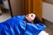 Woman in blue pressotherapy suit lying down having pressure therapy for weight loss in spa salon. Doctor help lose weight and