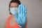 Woman with blue rubber glove make stop gesture.