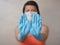 Woman with blue rubber glove make stop gesture