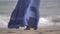 Woman blue skirt develops in the wind on the coast