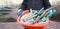 Woman in blue sport suit holding diffrent garden tools.