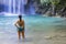 Woman in blue swimsuit look water at  Erawan Waterfall