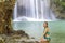 Woman in blue swimsuit relax in water at  Erawan Waterfall