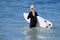 Woman board surfer heading out to the surf Laguna Beach, California.