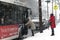 Woman boards bus during snow storm