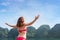 Woman on boat among the islands with arms up